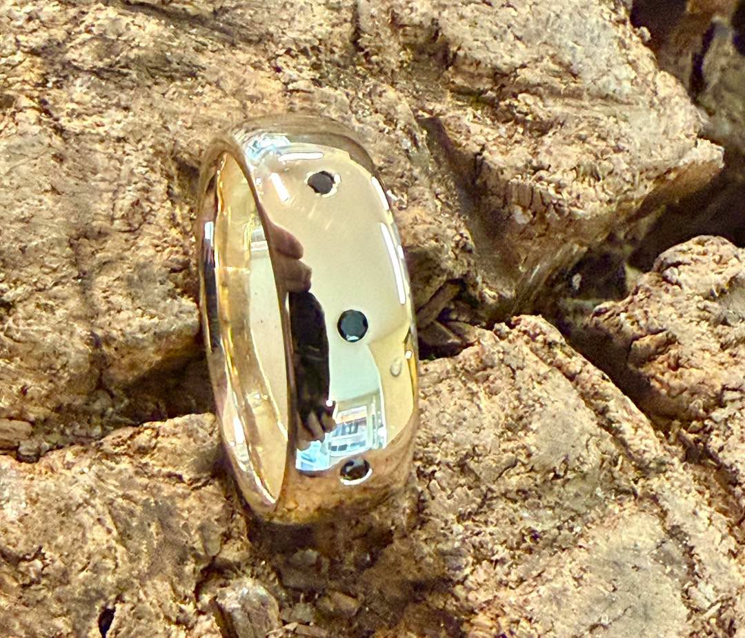 Broad yellow-metal ring with spaced dark inset details